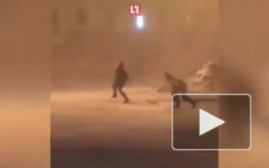 Сильный ветер в Норильске заставляет людей ползти по улице