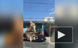 На Ланском шоссе грузовик с трактором на трале застрял под мостом